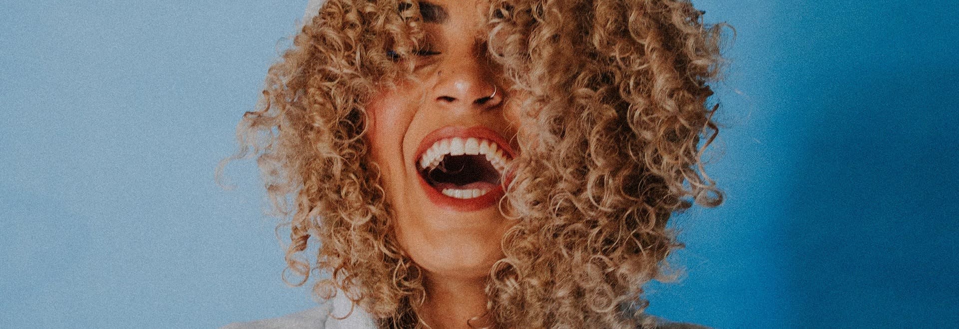 Picture of a smiling woman with very curly, blond hair