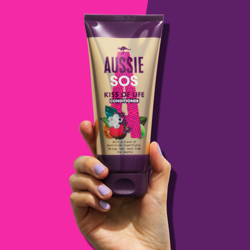 An image of a hand holding Aussie SOS Kiss of life Conditioner