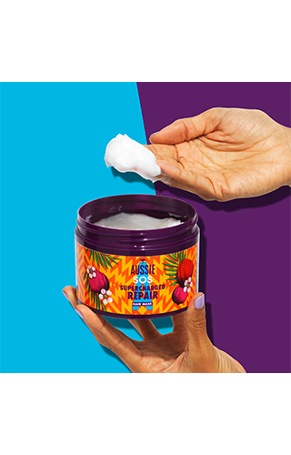 An image of Aussie InHand Repair Mask on hand above the package on the purple-blue background